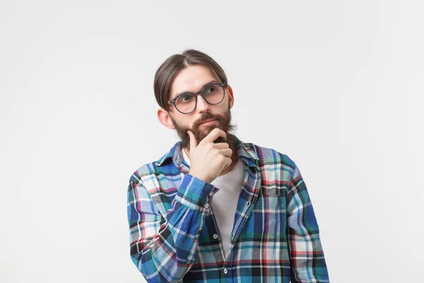 Concepto de emociones y personas - Hombre hipster barbudo pensando en algo sobre fondo blanco . — Foto de Stock