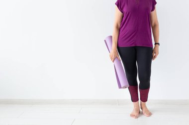 Yoga, meditasyon, insanlar kavramı - kadar yakın bir orta yaş kadın yoga ile beyaz arka plan kopya alanı ile onu mindere sonra
