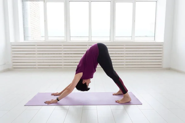 Deporte, yoga, concepto de personas - Mujer deportiva de mediana edad practicando yoga en interiores —  Fotos de Stock