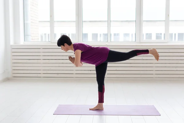 Yoga, concepto de personas - una mujer de mediana edad haciendo un yoga y tratar de hacer una asana —  Fotos de Stock