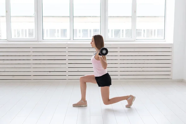 Fitness, deporte, concepto de personas - mujer joven en traje deportivo, guantes está en cuclillas con bar — Foto de Stock