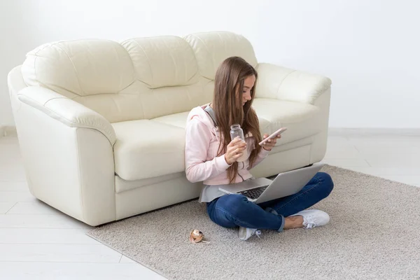 Concept freelance et personnes - Jeune femme assise sur le sol et travaillant à l'ordinateur portable — Photo