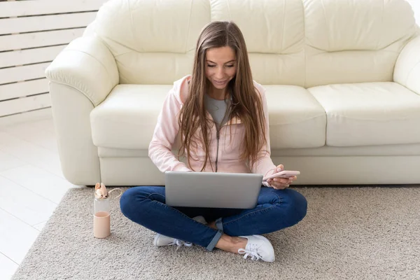 Concetto di freelance e persone - Giovane donna seduta sul pavimento e che lavora al laptop — Foto Stock