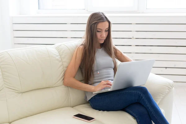 Technológiák, a szabadúszó és az emberek koncepció - laptop otthon dolgozó fiatal nő — Stock Fotó