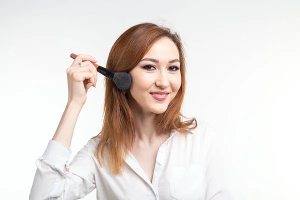 Make-up-Artist, Schönheit und Menschen Konzept - schöne koreanische junge Frau hält Make-up-Pinsel auf weißem Hintergrund — Stockfoto