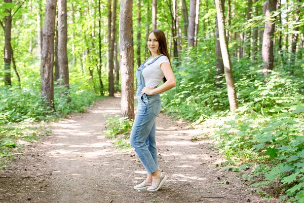 La gente, la moda y el concepto de la naturaleza - Retrato de hermosa mujer joven y elegante vestida con camiseta blanca y jeans —  Fotos de Stock
