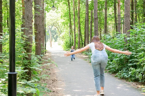 Natureza, família, conceito de pessoas - Filha de criança adorável e mulher jovem na bela floresta. Filha correndo para a mãe — Fotografia de Stock