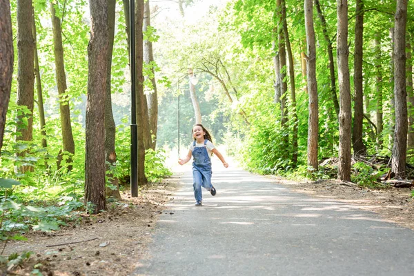 Kinderen, jeugd en natuur concept - portret van mooi klein kind meisje loopt door het park — Stockfoto