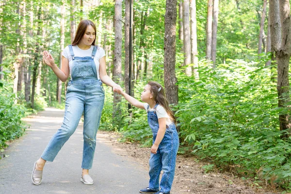 Család és a természet koncepció - vonzó fiatal nő szórakozni vele a kis lányom a parkban — Stock Fotó