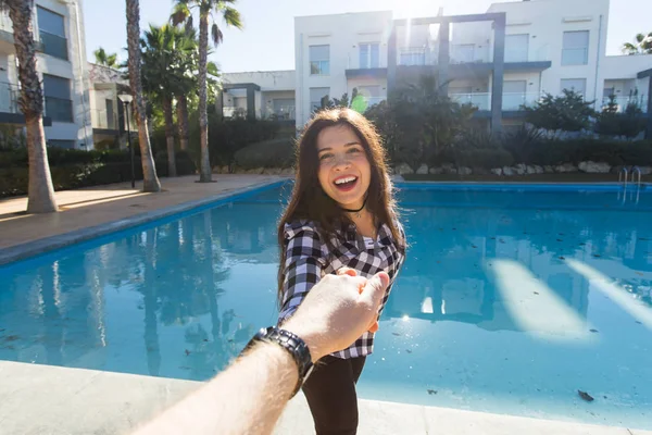 付いて来てください。休暇の概念。リゾート プールの近くで彼氏の手を握って幸せな若い女 — ストック写真
