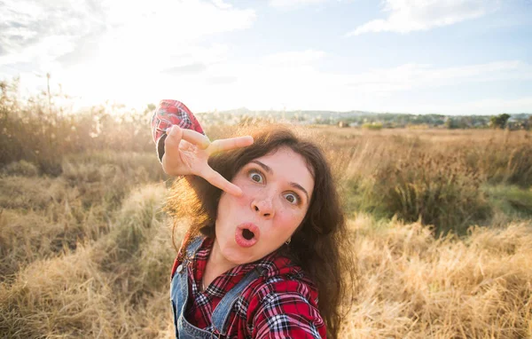 Viajes, turismo y concepto de la naturaleza - Mujer joven jugando alrededor de tomar selfie en el campo —  Fotos de Stock