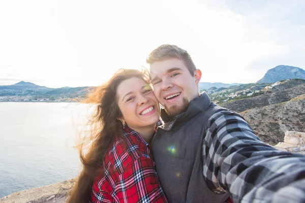 Koncepcja podróży, wakacji i wczasów - para piękny posiadające zabawy, biorąc selfie, szalony twarze emocjonalne i śmiejąc się. — Zdjęcie stockowe