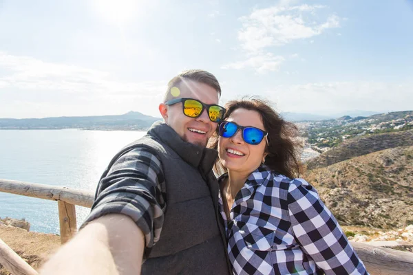 Vakantie-, vakantie- en reisinformatie concept - Beautiful couple having fun, nemen selfie, gek emotionele gezichten en lachen. — Stockfoto