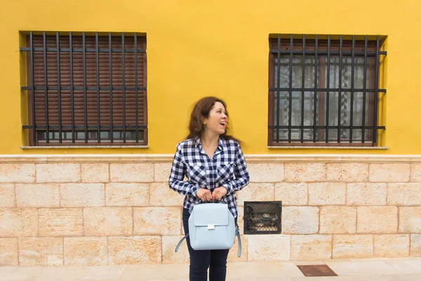Jonge grappige emotionele vrouw met handtas poseren op stedelijke achtergrond — Stockfoto
