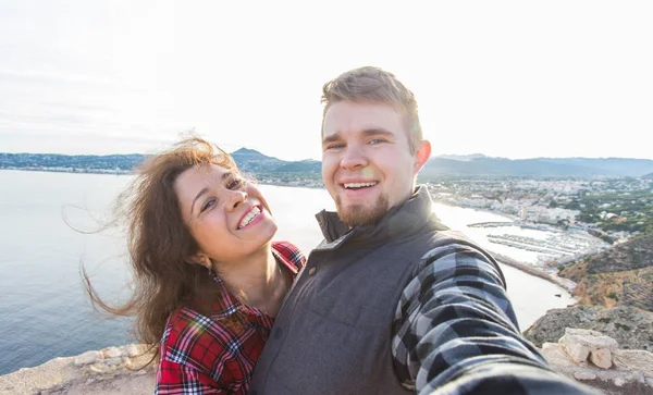 Conceito de viagem, férias e férias - Belo casal se divertindo, tirando selfie, rostos emocionais loucos e rindo . — Fotografia de Stock