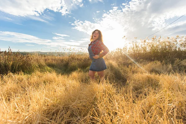 Verano, libertad y concepto de vacaciones - Mujer joven disfrutando de la naturaleza y la luz del sol en el campo de paja — Foto de Stock