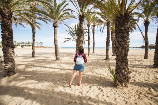 Férias de verão, férias e conceito de viagem - Mulher bonita sob ramos das palmeiras junto ao mar — Fotografia de Stock