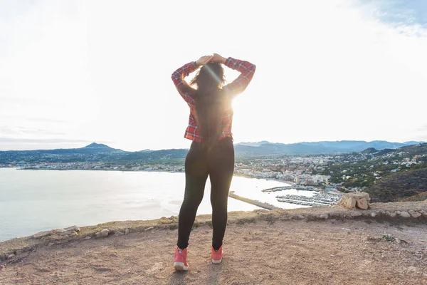 Conceito de viagem, viagem e viagem - Visão traseira da jovem mulher bonita de pé na borda do penhasco e olhando para o mar — Fotografia de Stock