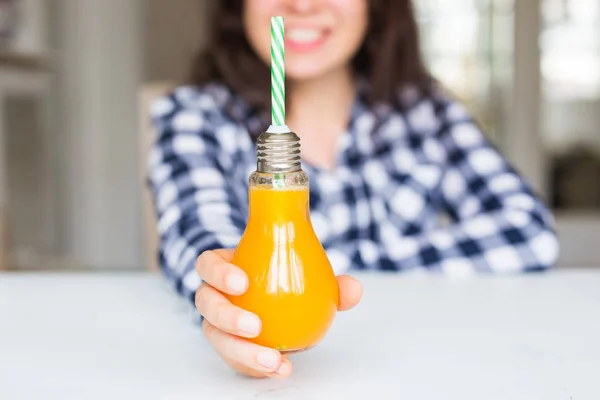 Dieta, estilo de vida saudável e conceito de desintoxicação close-up de mulher com suco de laranja em garrafa se parece com uma lâmpada — Fotografia de Stock
