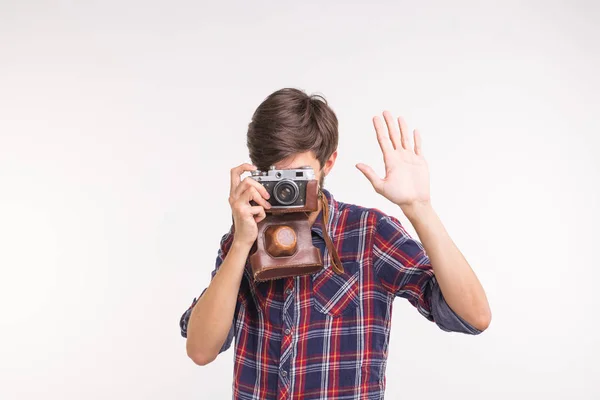 Conceito de hobby e lazer de pessoas - jovem hipster homem usando sua câmera vintage no fundo branco — Fotografia de Stock