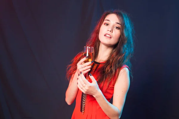 Алкоголь, свята та концепція вечірки - жінка в червоній сукні з шампанським або келихом на темному фоні з місцем для тексту — стокове фото