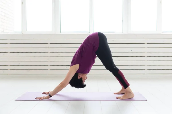 Yoga, concepto de personas - una mujer de mediana edad haciendo un yoga y tratar de hacer una asana —  Fotos de Stock