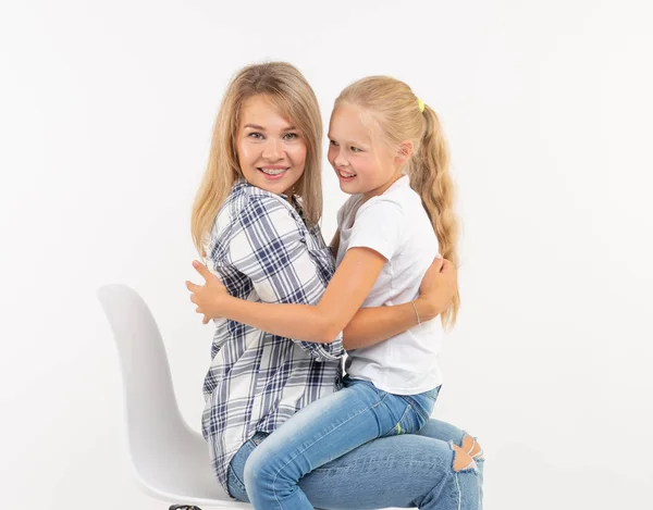 Ouderschap, gezin en kinderen concept - portret van een moeder en haar kind meisje veel plezier en lacht op witte achtergrond — Stockfoto