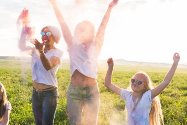 Hint bayram, eğlenceli ve Holi festival kavramı - mutlu kadın ve kız çocuklarının atlama boya atmak kadar renkli toz kaplı