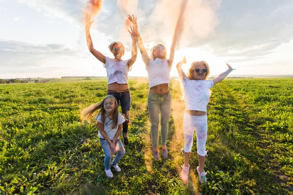 Kul, färger, indiska helgdagar och människor koncept - unga kvinnliga människor att ha kul på festivalen Holi — Stockfoto