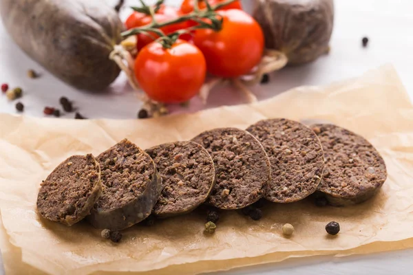 Essen, Küche und Pferdefleischkonzept - Fleischwurst in Nahaufnahme mit Tomaten und Paprika auf Kraftpapier — Stockfoto