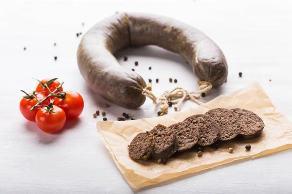 Food, meat and delicious concept - sausages made with horse meat with tomatoes on table — Stock Photo, Image