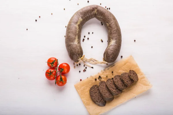 Food, horse meat and delicious concept - top view of sliced sausage with tomato and pepper