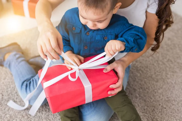 Děti, narozeniny a svátek koncept - malé dítě chlapec otevření červené krabice s současnost — Stock fotografie