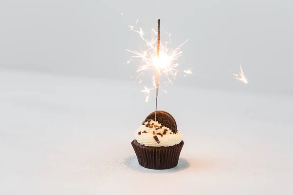 Cibo, festa e concetto di vacanza - Cupcake di compleanno con sparkler su sfondo bianco — Foto Stock