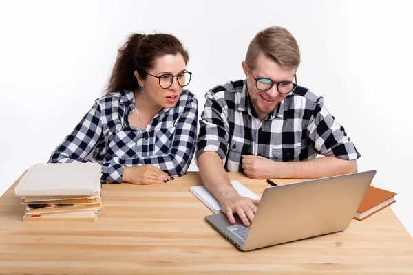 Ανθρώπους και εκπαίδευση έννοια - δύο μαθητές ντυμένοι με καρό πουκάμισο που κάθεται σε ένα τραπέζι — Φωτογραφία Αρχείου