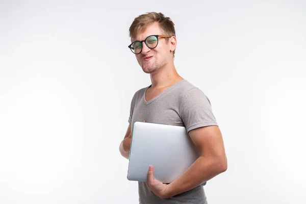 Edukacja i koncepcja ludzie - student przystojny mężczyzna w okularach wygląda jak zadowolony z laptopa na białym tle z miejsca kopii — Zdjęcie stockowe