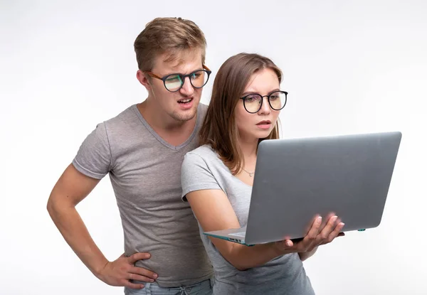 Persone e concetto di istruzione - Due giovani studenti in cerca di laptop su sfondo bianco — Foto Stock