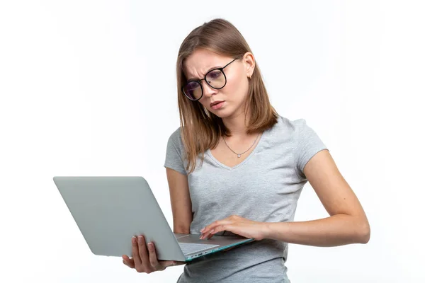 Étude, éducation, concept de personnes - jeune étudiante en lunettes texter quelque chose sur un ordinateur portable et ressemble à elle est très occupée — Photo