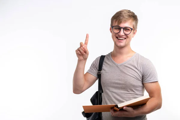 Educación, universidad, idea y concepto de personas: estudiante con libro que muestra el dedo en el fondo blanco con espacio para copiar — Foto de Stock