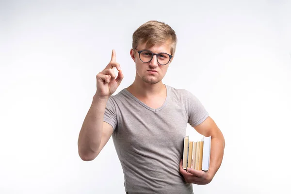 Persone, conoscenza ed educazione - Ritratto di uno studente vestito con una t-shirt grigia che tiene in mano dei libri — Foto Stock