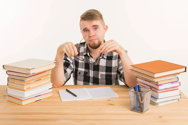 Concepto de conocimiento, estudiante y educación: el tipo cansado se sienta a la mesa y toma notas en un cuaderno — Foto de Stock