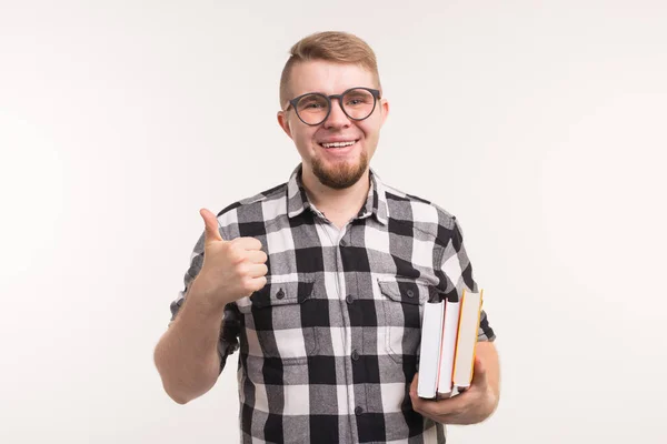 Concepto de personas y educación - Estudiante sonriente sosteniendo libros y haciendo gestos con los pulgares hacia arriba sobre fondo blanco — Foto de Stock