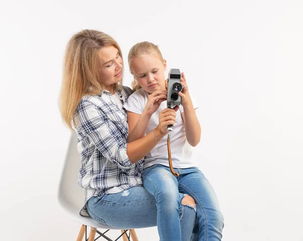 Aile, fotoğraf ve hobi kavramı - kadın ve beyaz arka plan üzerinde bir eski moda kamera ile çocuk — Stok fotoğraf