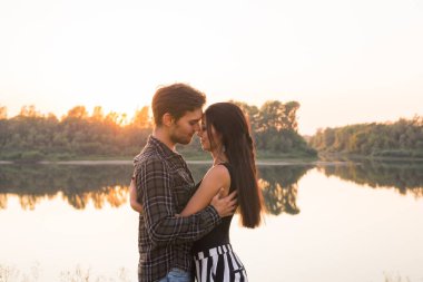 Şefkat, sevgi ve doğa kavramı - güzel kadın ve yakışıklı adam su arka plan üzerinde sarılma