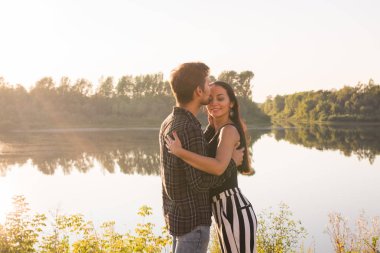 İlişki, aşk ve doğa kavramı - çekici kadın ve sarılma ve öpüşme su arka plan üzerinde yakışıklı adam