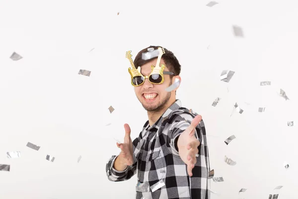 Personas, vacaciones y concepto de fiesta - joven en gafas bailando en confeti sobre fondo blanco — Foto de Stock