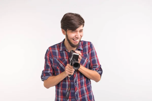 Concepto vintage y de personas: el hombre mira a través de la cámara retro sobre el fondo blanco — Foto de Stock