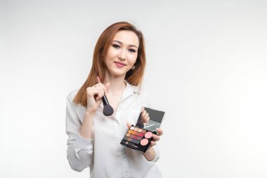 Güzellik makyaj sanatçısı. Kadar yakın Kore güzel genç kadın oldukça gülümseyen holding göz gölge paleti fırça beyaz arka plan üzerinde