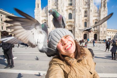 Kış seyahat, tatil ve kuşlar kavramı - selfie güvercinler yakınındaki Milan Katedrali Duomo di Milano, İtalya ile alarak genç komik kadın.