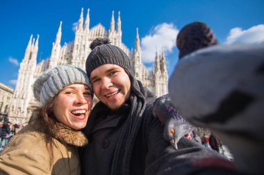 Milano Duomo Meydanı'nda güvercin ile kendi kendine portre çekici çift. Kış seyahat, İtalya ve ilişki kavramı